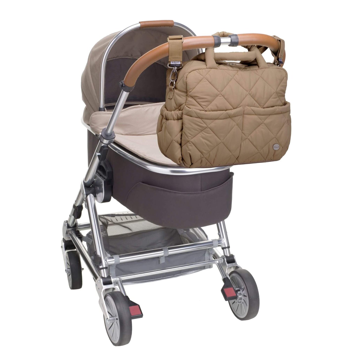 Soft quilted Babymel Willow Convertible Changing Bag in oatmeal, securely attached to a pram with built-in stroller straps for hands-free convenience.