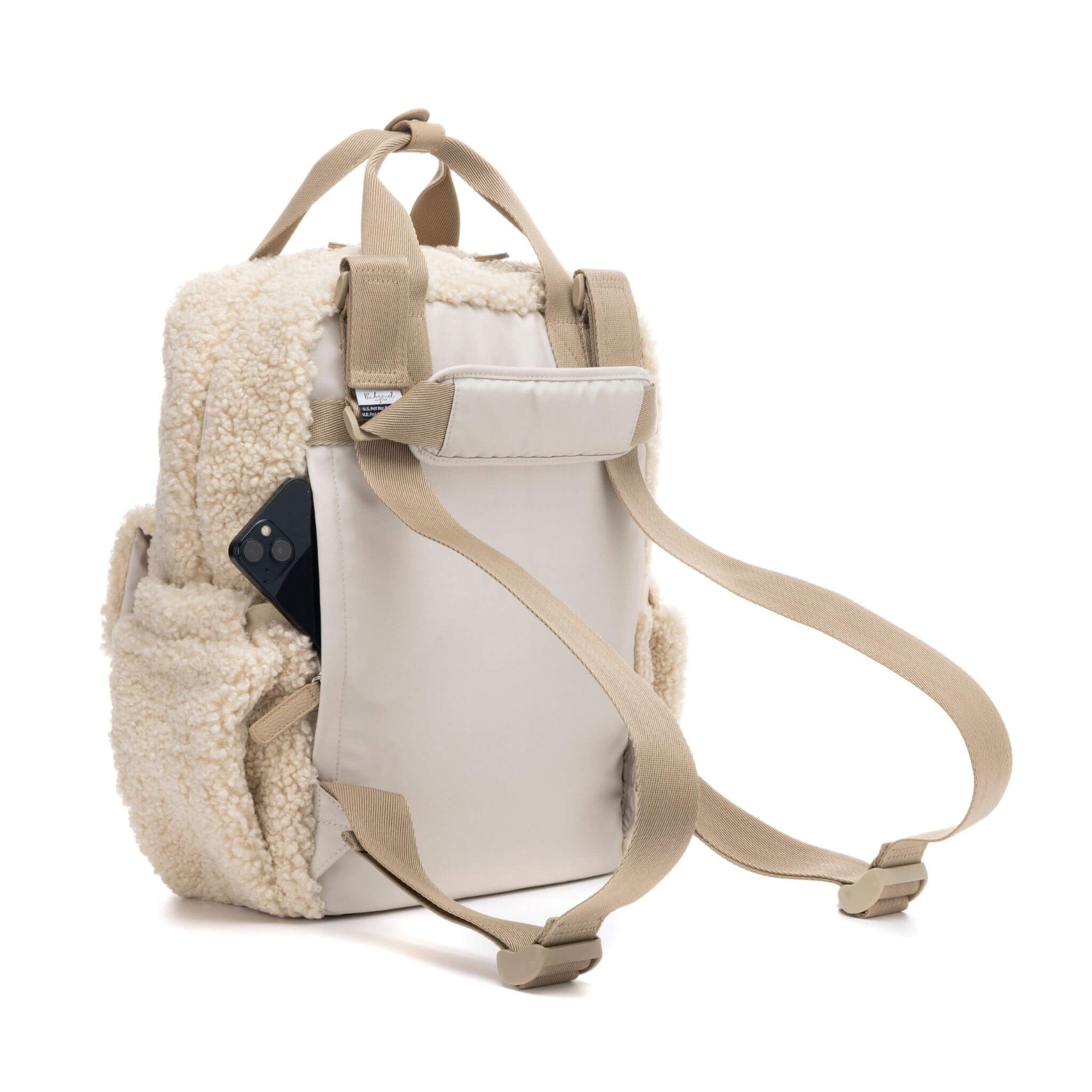 Cream Babymel Teddy Convertible Backpack with soft borg fleece, showing adjustable backpack straps, a luggage sleeve, and a hidden back pocket for valuables.