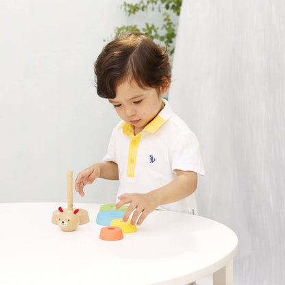 Child playing with the Classic World Bear Tower, arranging colourful wooden rings to build coordination and motor skills.