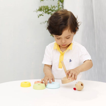 Child exploring the Classic World Bear Tower, stacking colourful wooden rings to enhance fine motor skills and coordination.