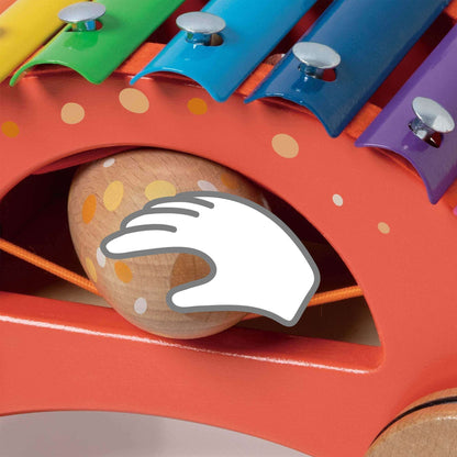 Close-up of the Classic World Dinosaur Xylophone showing the maraca stored under the vibrant rainbow keys with a playful hand icon.