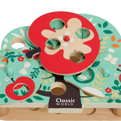 A close-up view of the Classic World Doctor Woodpecker toy showcasing its colourful wooden apple tree design with cut-out holes for worms.