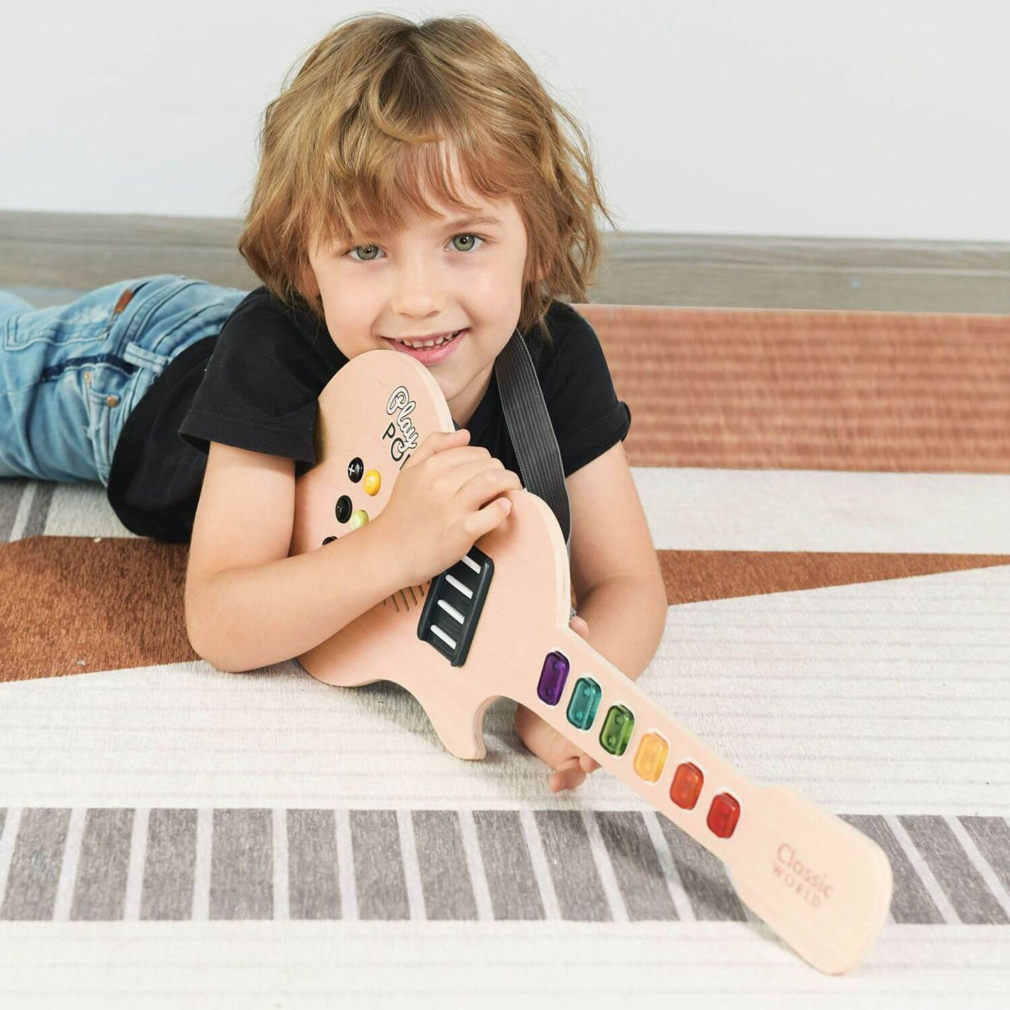 Smiling child holding the Classic World Electric Glowing Wooden Guitar, ready to explore colourful keys and creative sound effects.