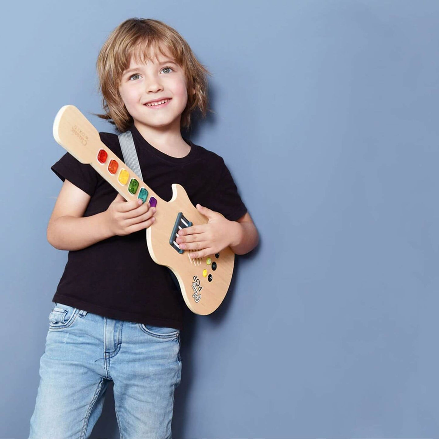 Child joyfully holding the Classic World Electric Glowing Wooden Guitar, showcasing its colourful keys and fun musical features.