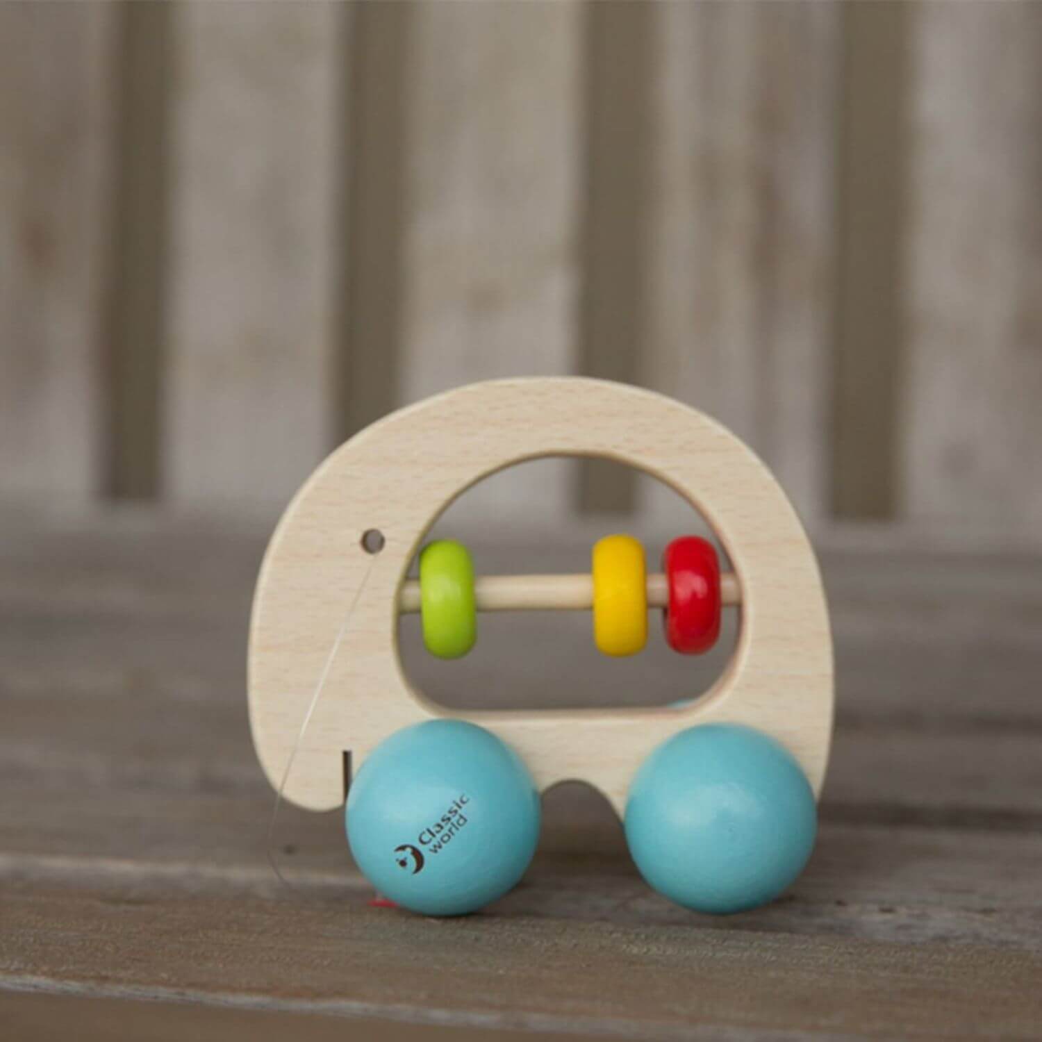 A Classic World Elephant Rattle made from beech wood, featuring colourful beads and smooth blue wheels, perfect for sensory play and motor skills.