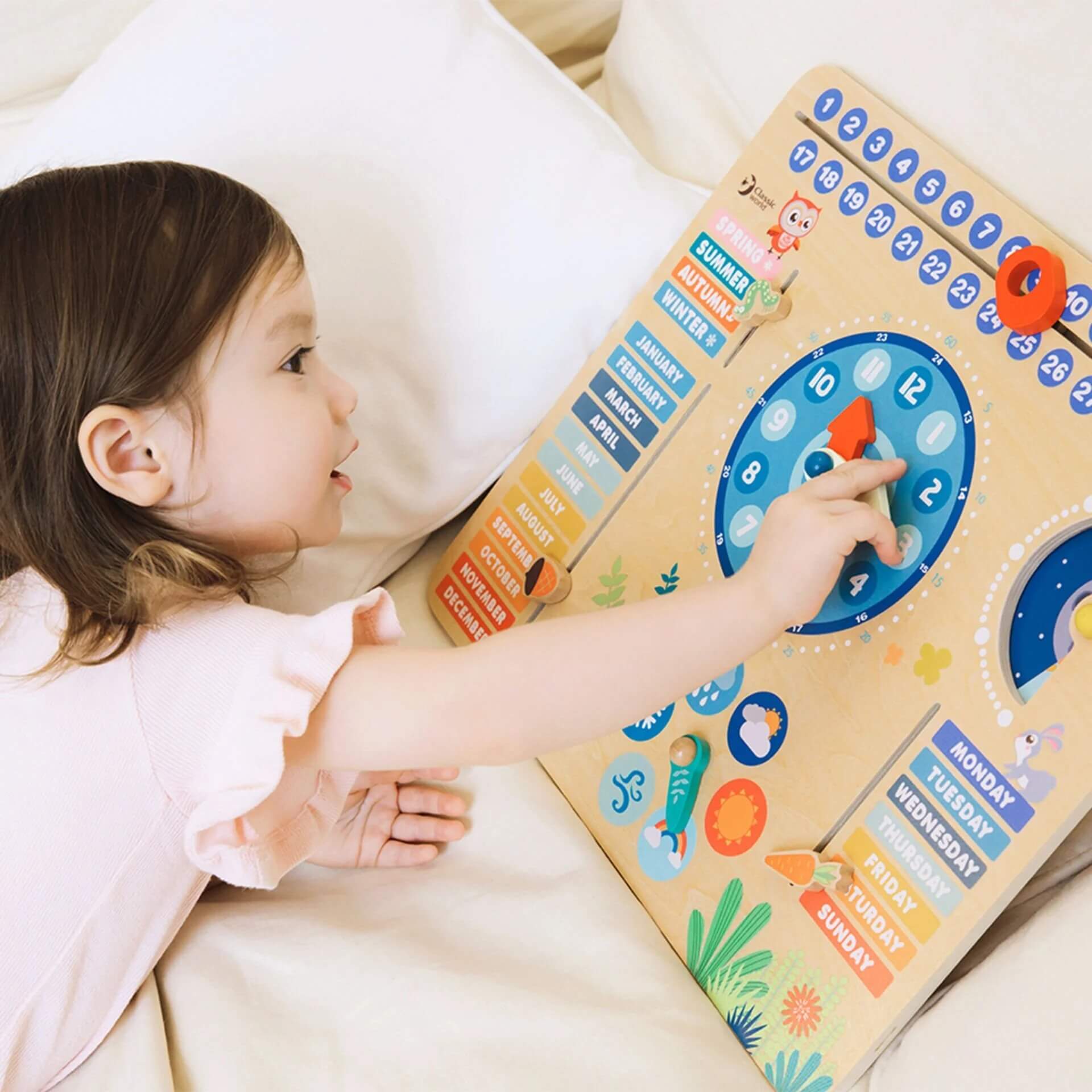 Child interacting with the Classic World Forest Calendar, adjusting dials and sliders to learn about time, seasons, and weather.