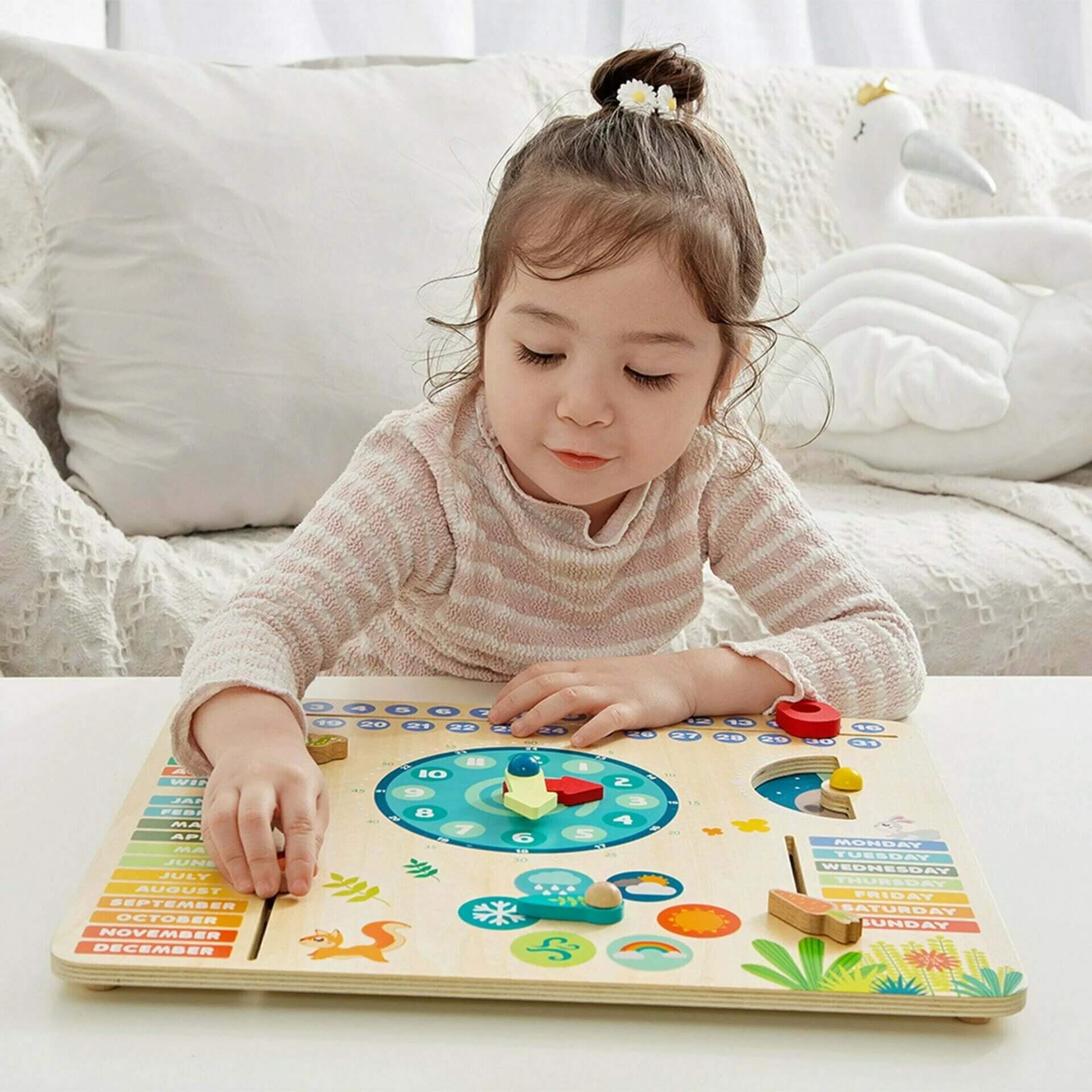 Child exploring the Classic World Forest Calendar, engaging with sliders and dials to learn about days, months, seasons, and weather.