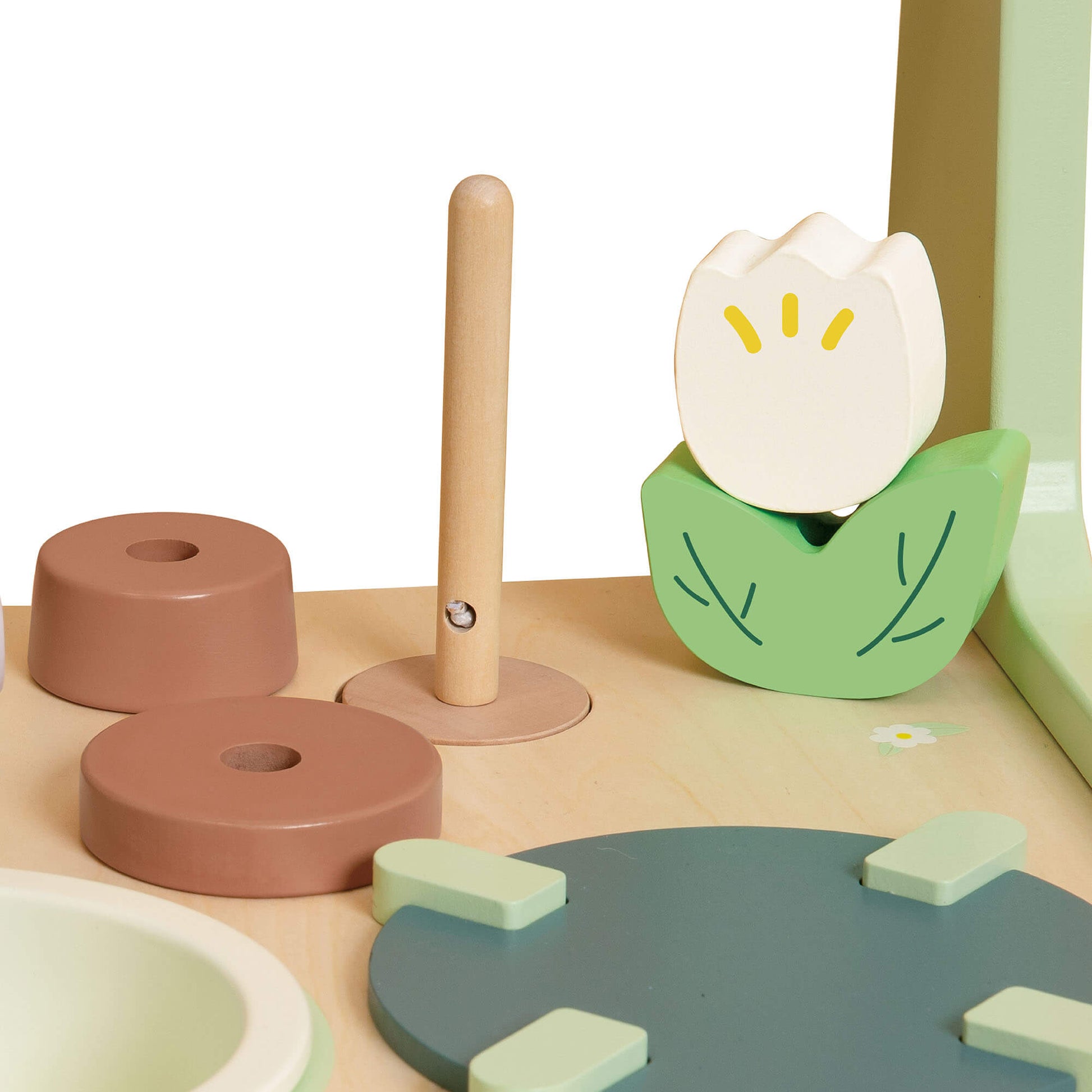 Close-up of the Classic World Kitchen Walker play kitchen top, featuring a wooden flower, stacking rings, and stove  for imaginative play.