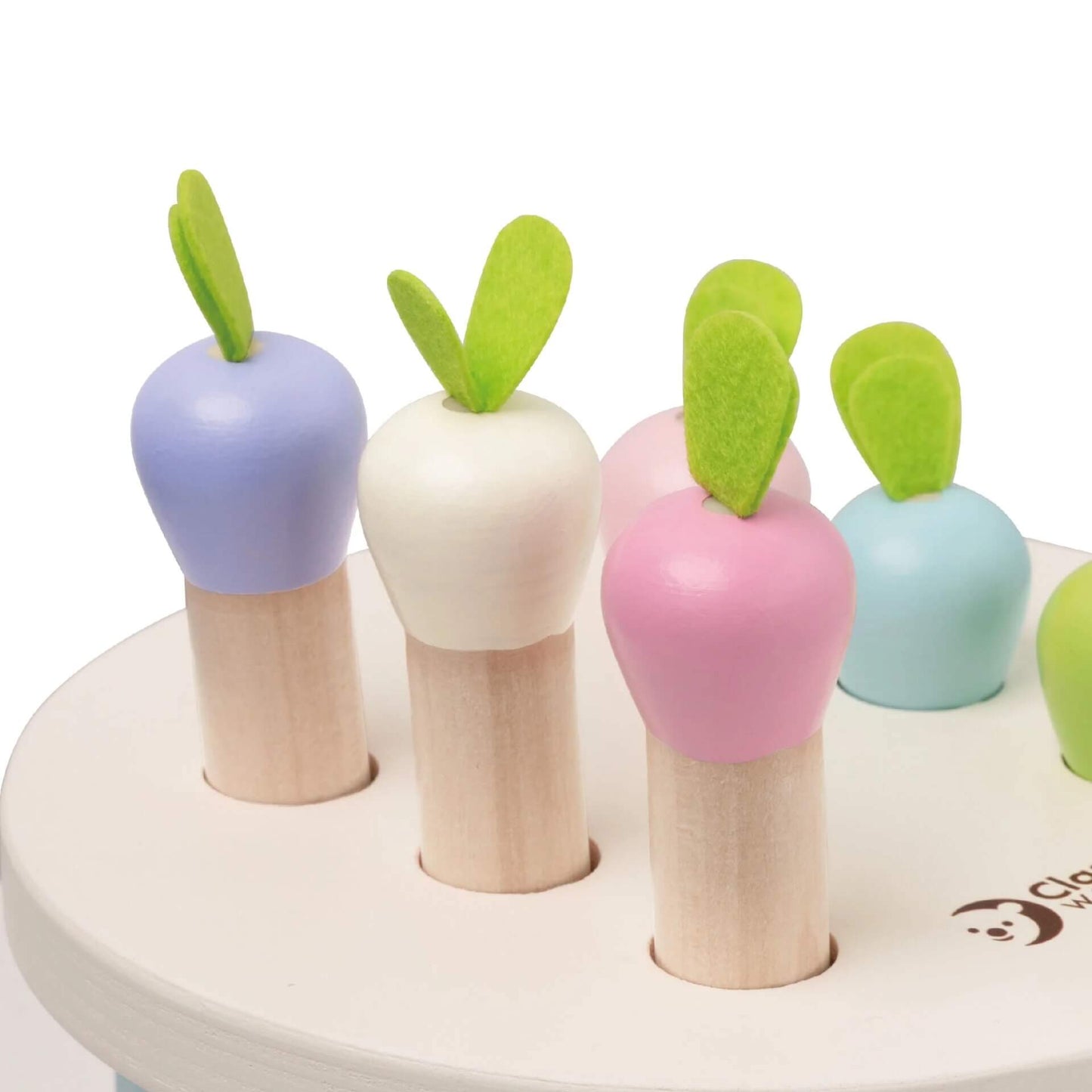 A close-up of the Classic World Mara Pounding Game showcasing pastel wooden carrots with felt leaves, perfect for interactive play.