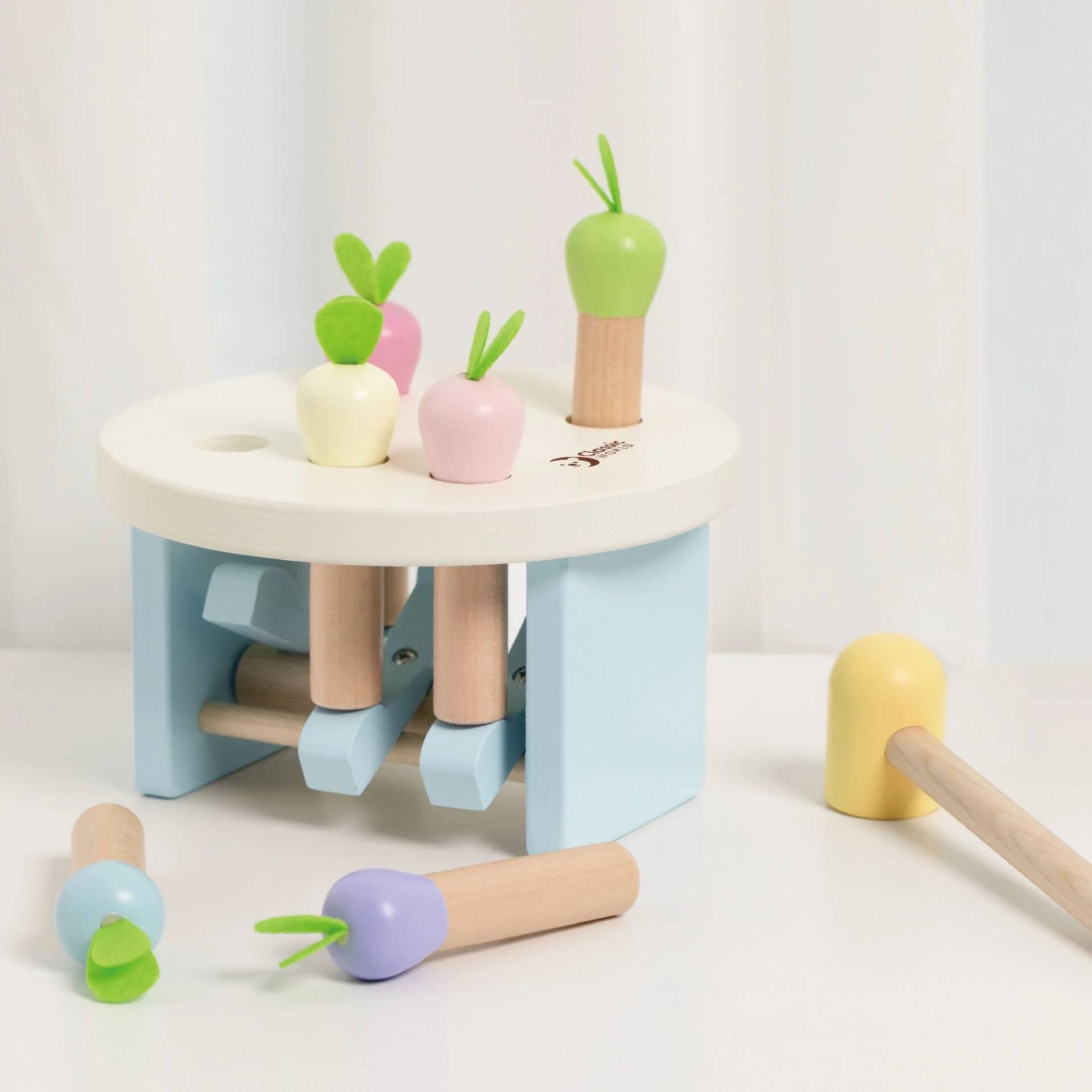 The Classic World Mara Pounding Game with pastel carrots, a wooden hammer. Designed for fun and skill-building playtime.