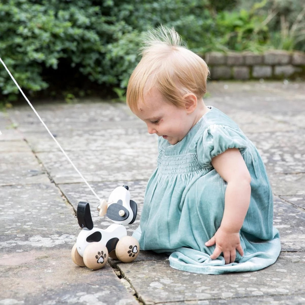 Child playing outdoors with the Classic World Pull Dog.