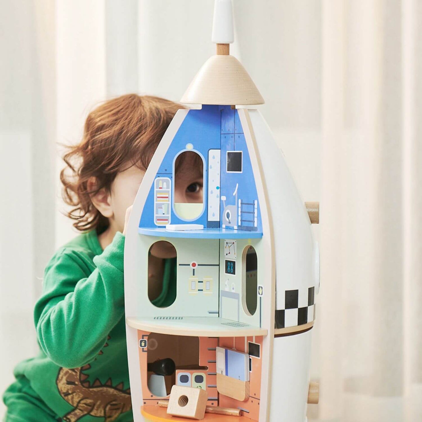 Child playing with the Classic World wooden rocket ship, showcasing colourful interior rooms designed for imaginative and creative play.