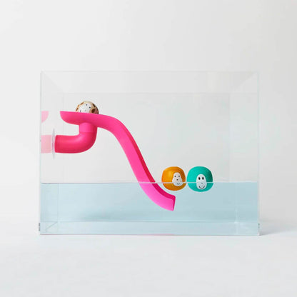 Pink Matchstick Monkey slide set attached to the side of a transparent bath with three floating animal rocks, ideal for water play