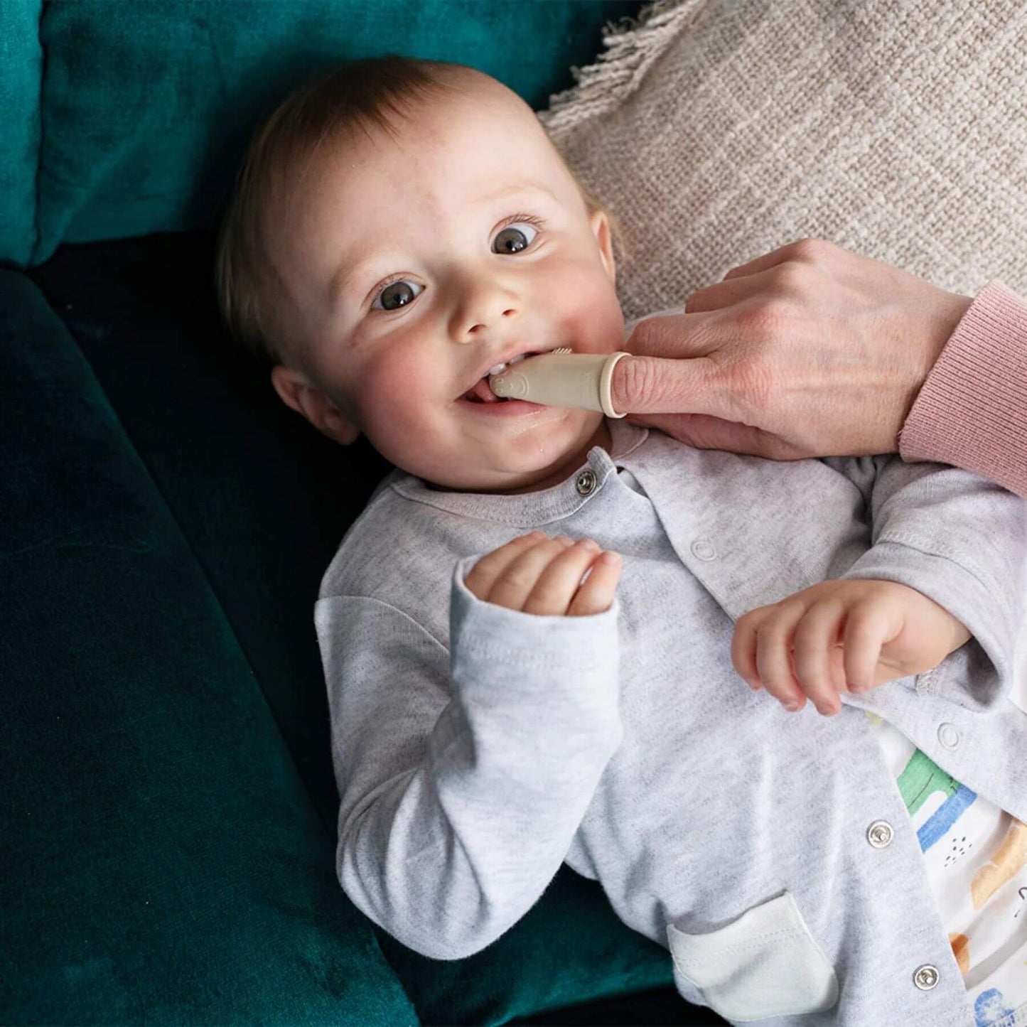 Baby using Matchstick Monkey silicone finger toothbrush from the teething starter set, ideal for soothing gums and early dental care.