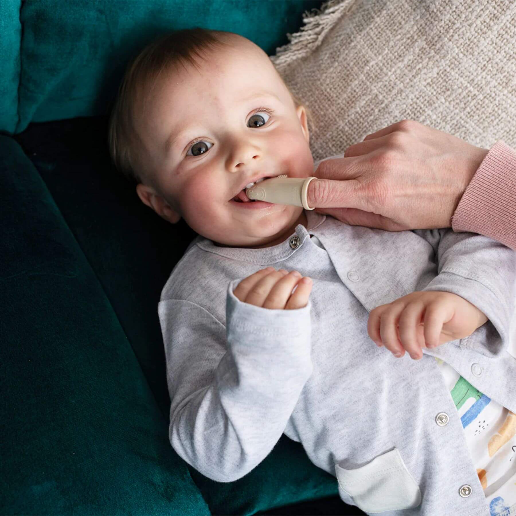 Baby using Matchstick Monkey silicone finger toothbrush from the teething starter set, ideal for soothing gums and early dental care.