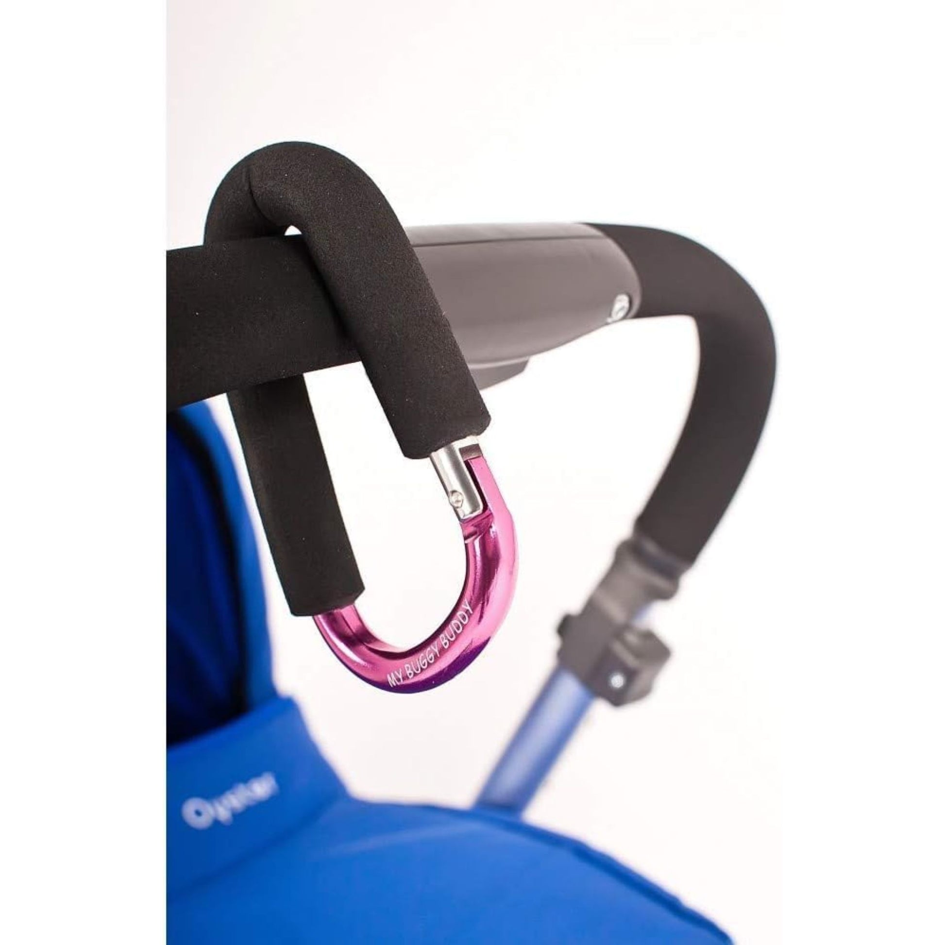 Pink My Buggy Buddy clip fastened to a stroller handle, ideal for holding bags and essentials, providing hands-free convenience for parents.