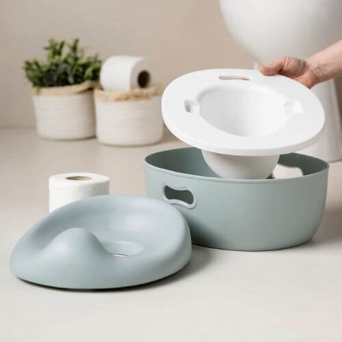 Green Nattou 3-in-1 Potty disassembled, showing its removable parts for easy cleaning and versatile potty training use.