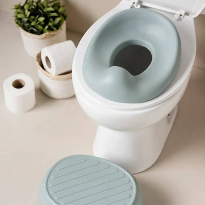 Green Nattou potty seat placed on a toilet, demonstrating its use as a toilet seat reducer for toddlers transitioning to the toilet.