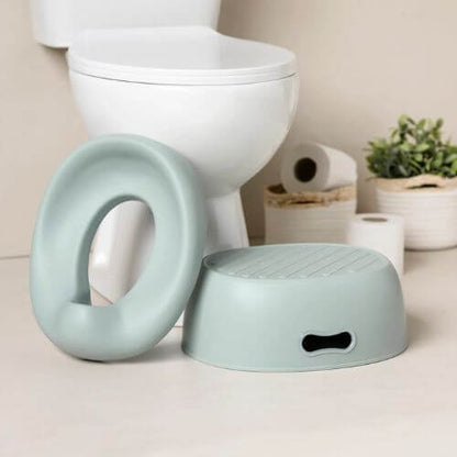 Green Nattou potty seat and step stool placed beside a toilet, showing its adaptable potty training functions.