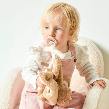 Toddler with Nattou Teddy Rhino Doudou comfort blanket, demonstrating its soothing design and pacifier attachment feature.