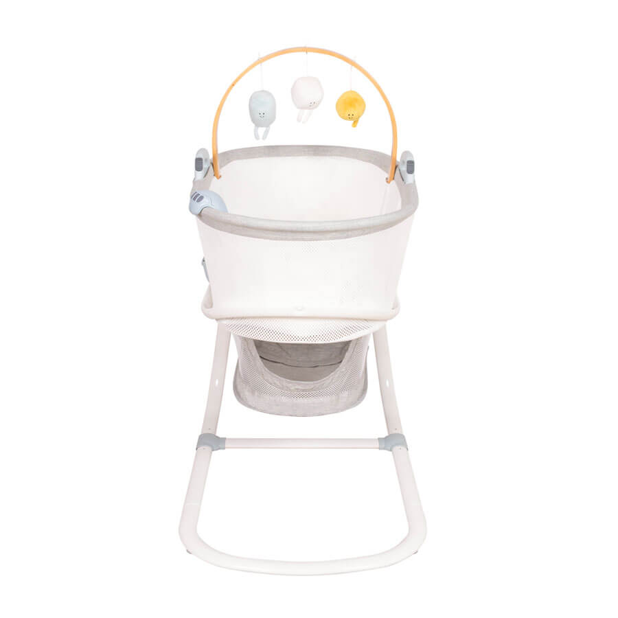 Front view of Purflo breathable crib, featuring mesh sides for airflow, a storage basket, and a wooden mobile arch with soft hanging toys. Modern design.