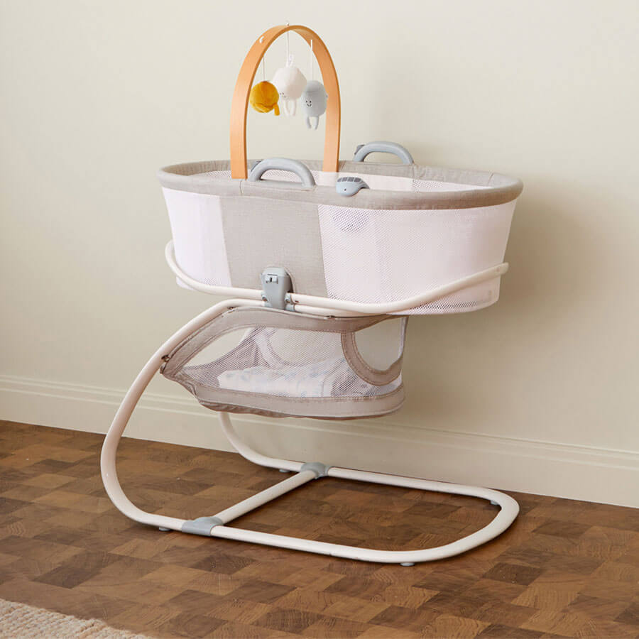 Purflo breathable crib with mesh sides for airflow, modern beige and grey design, wooden mobile arch with plush toys, and a convenient storage basket underneath.