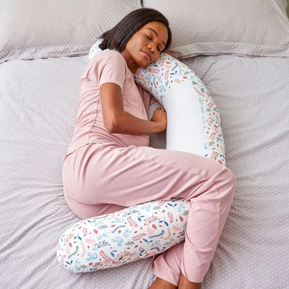 Woman sleeping comfortably with the Purflo Breathe Pregnancy Pillow in Botanical print, providing ergonomic support and featuring breathable fabric.