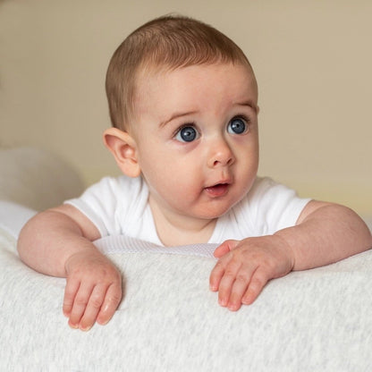 Baby peeking over the Purflo Breathe Pregnancy Pillow in minimal grey.