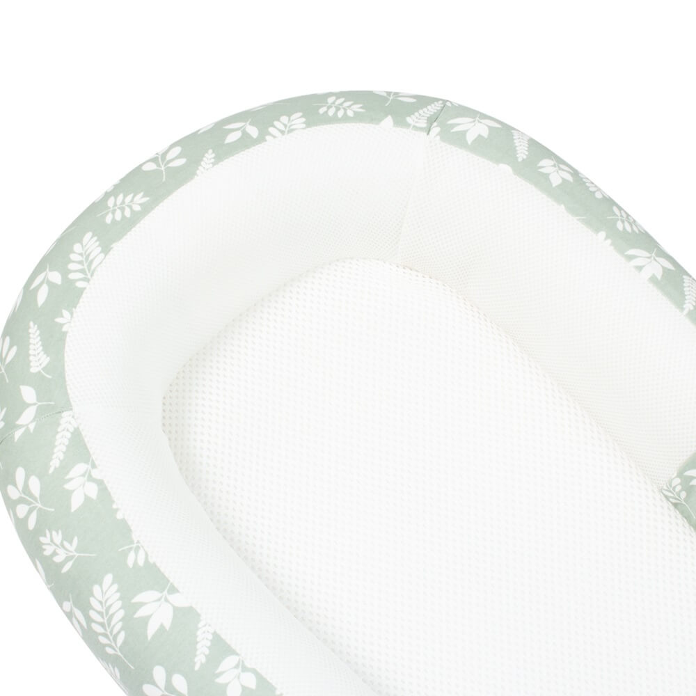 Close-up view of the Purflo Sleeptight Baby Bed in Fern print, showing the soft green cover with white leaf designs and a breathable mesh interior.