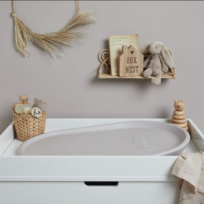 Shnuggle Squishy Changing Mat in taupe on nursery changing table, surrounded by soft decor and baby essentials for a cosy setup.