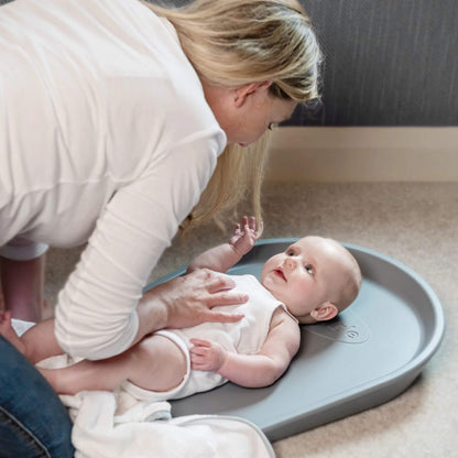 Mother engaging with her baby lying on the Shnuggle Squishy Changing Mat in grey, creating a nurturing and intimate moment.