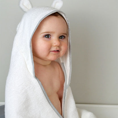 Smiling baby wrapped in a Shnuggle wearable bath towel with hood and cute ear detail, perfect for cosy and hands-free drying.