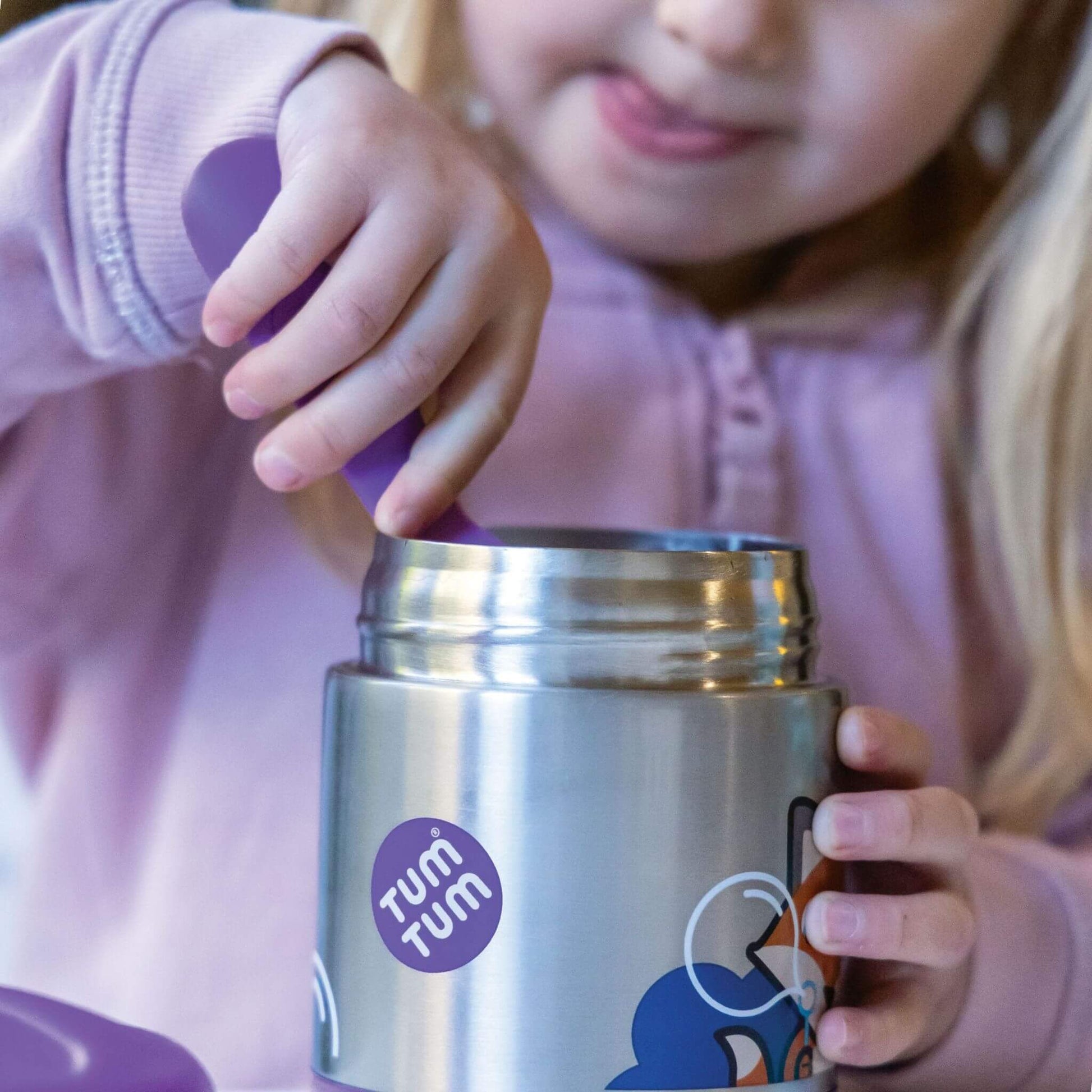 Child using the TUM TUM Felicity Fox insulated food flask, eating from the flask with a purple spork, perfect for hot or cold meals.