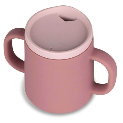 A pink TUM TUM silicone sippy cup featuring dual handles for easy holding and a soft silicone spout lid. The spill-resistant design is ideal for toddlers learning to drink independently, and the lid ensures mess-free use.