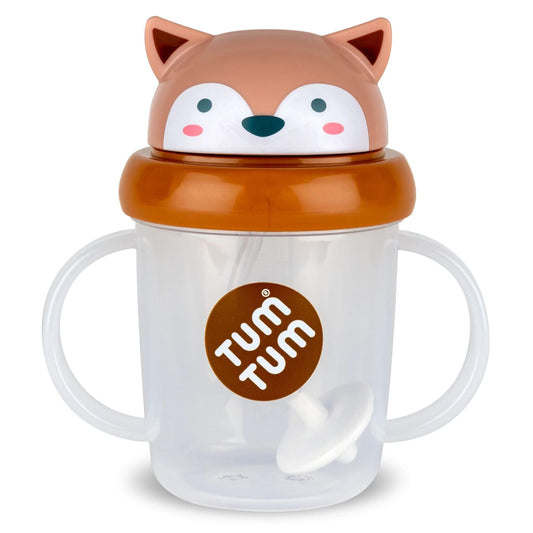 A clear TUM TUM Tippy Up Cup, featuring Fergus Fox lid with handles on both sides for easy gripping. The cup includes a weighted straw that follows the liquid, allowing toddlers to drink comfortably from any angle.