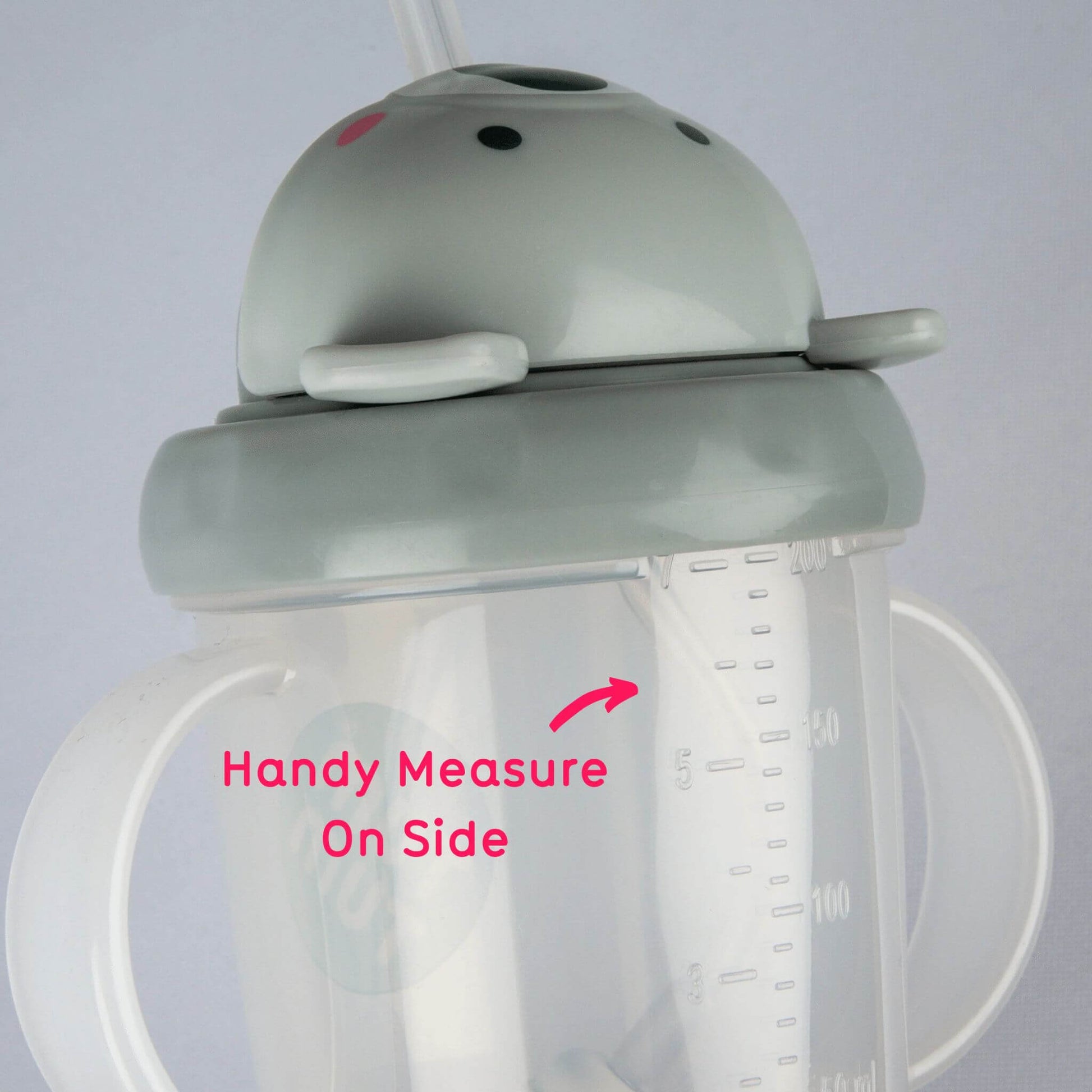 A close-up of the TUM TUM Tippy Up Cup, featuring a Kev Koala lid and dual handles. The cup shows a handy measurement scale on the side for easy tracking of fluid intake. The weighted straw inside follows the liquid for smooth, any-angle drinking.