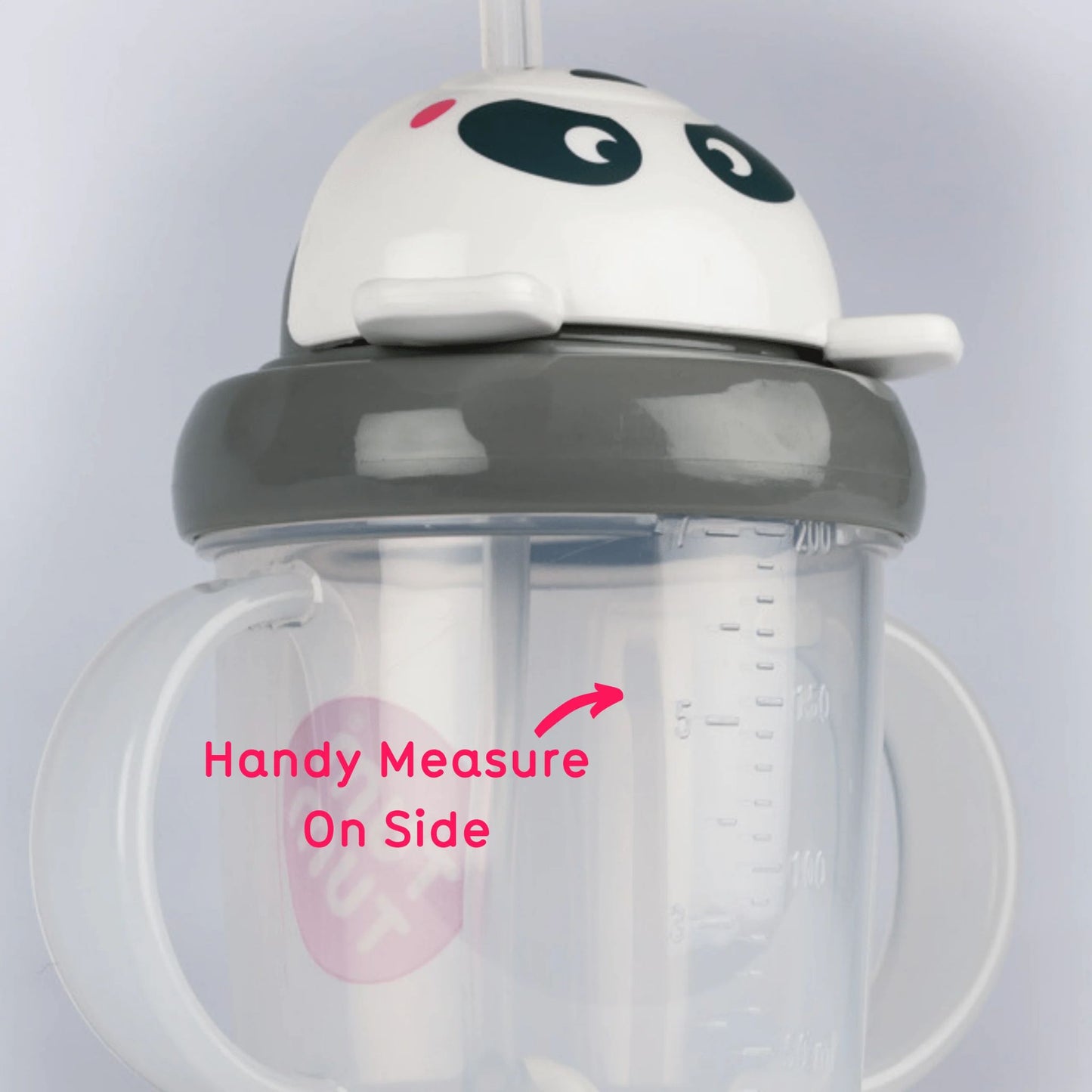 A close-up of the TUM TUM Tippy Up Cup, featuring a panda bear lid and dual handles. The cup shows a handy measurement scale on the side for easy tracking of fluid intake. The weighted straw inside follows the liquid for smooth, any-angle drinking.