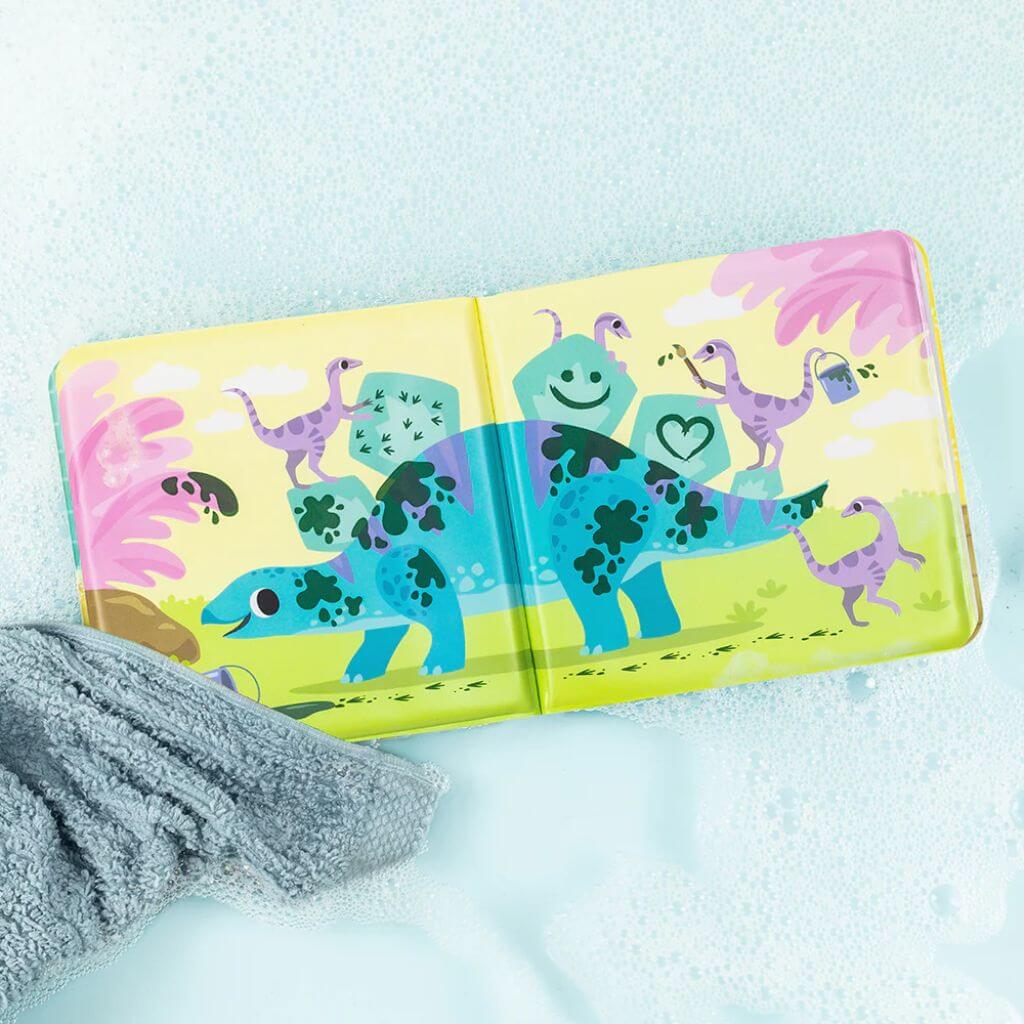 Tiger Tribe Messy Dinosaurs Bath Book open on a bubbly surface, showing dinosaurs with mud spots that change with water temperature, ideal for interactive bath play.