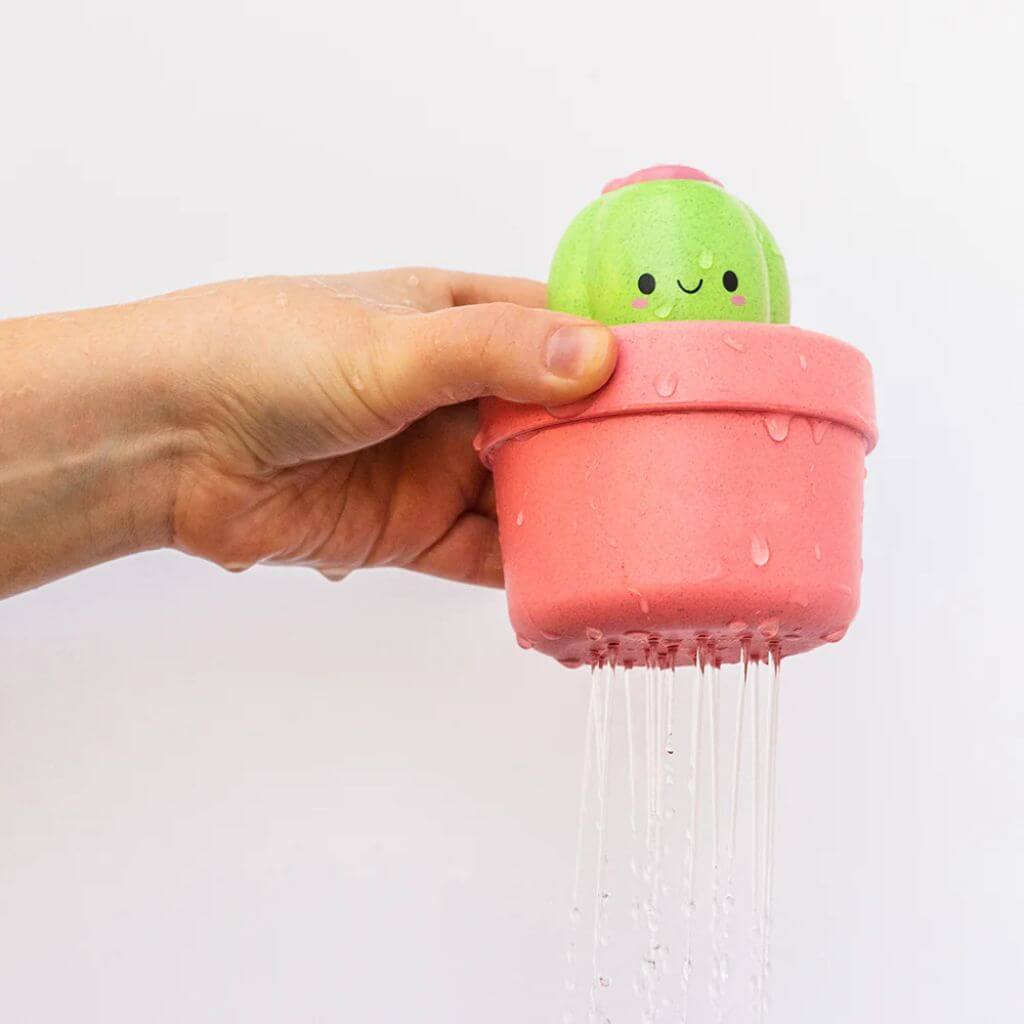 Hand holding the Tiger Tribe pop-up cactus bath toy, with water gently streaming from the base, perfect for sensory bath play.