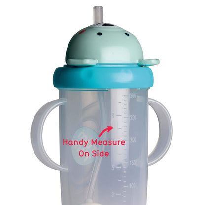 A clear sippy cup with dual handles, featuring a blue bear lid and a built-in straw. The cup has a flip-top lid and a measuring scale on the side to track fluid intake, ideal for toddlers.