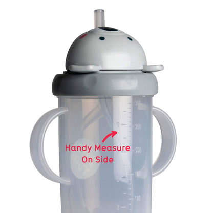 A clear sippy cup with dual handles, featuring a koala bear lid and a built-in straw. The cup has a flip-top lid and a measuring scale on the side to track fluid intake, ideal for toddlers.