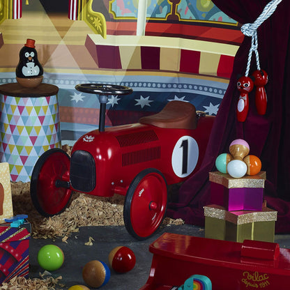 Vilac Classic Metal Car in red with a brown seat and number 1 detail, displayed in a colourful, circus-themed setting with toys and decorations.