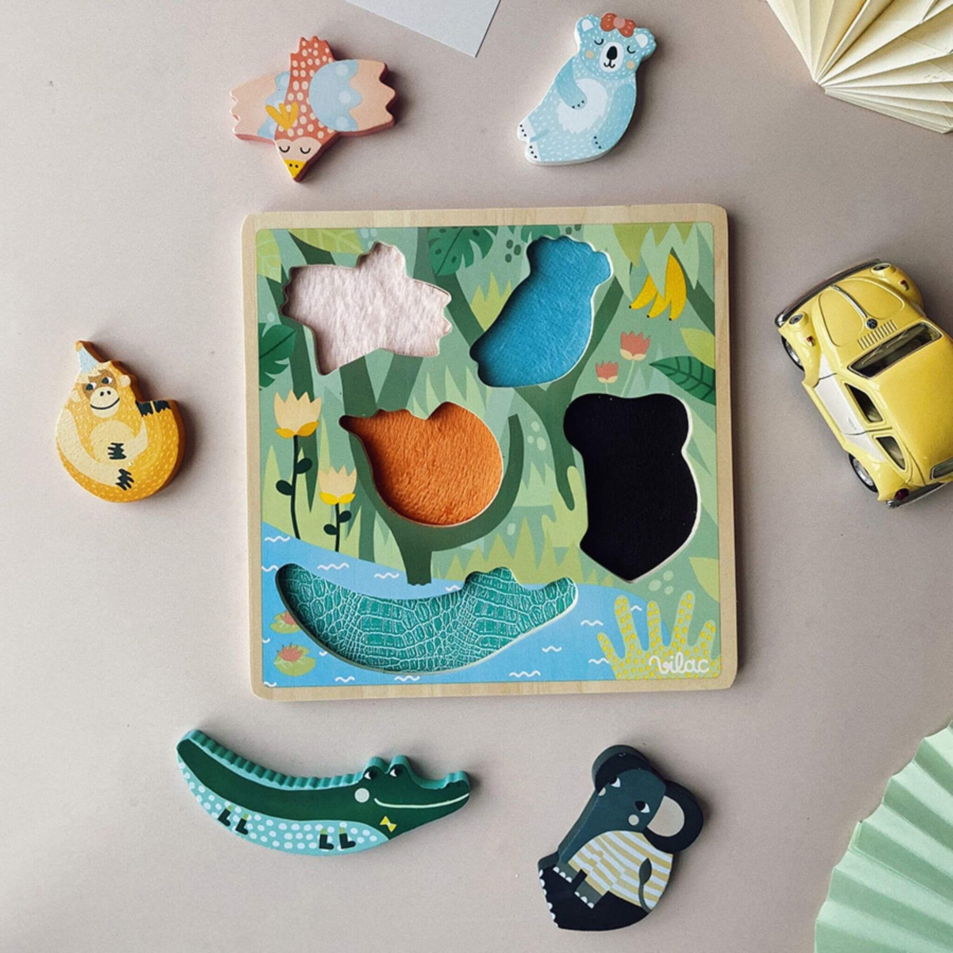 Vilac Jungle Touch and Feel Puzzle displayed with colourful wooden animal pieces and a tactile jungle-themed board on a table.