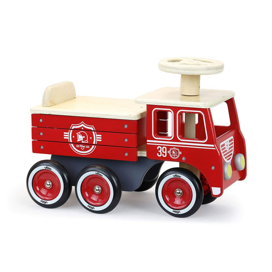 A beautifully crafted Vilac Ride-On Fire Truck with a vintage red design, rubber tyres, steering wheel, and storage under the seat for toys.