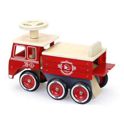 A sturdy Vilac Ride-On Fire Truck with a built-in toy storage compartment, red rubber tyres, and a classic design for endless adventures.